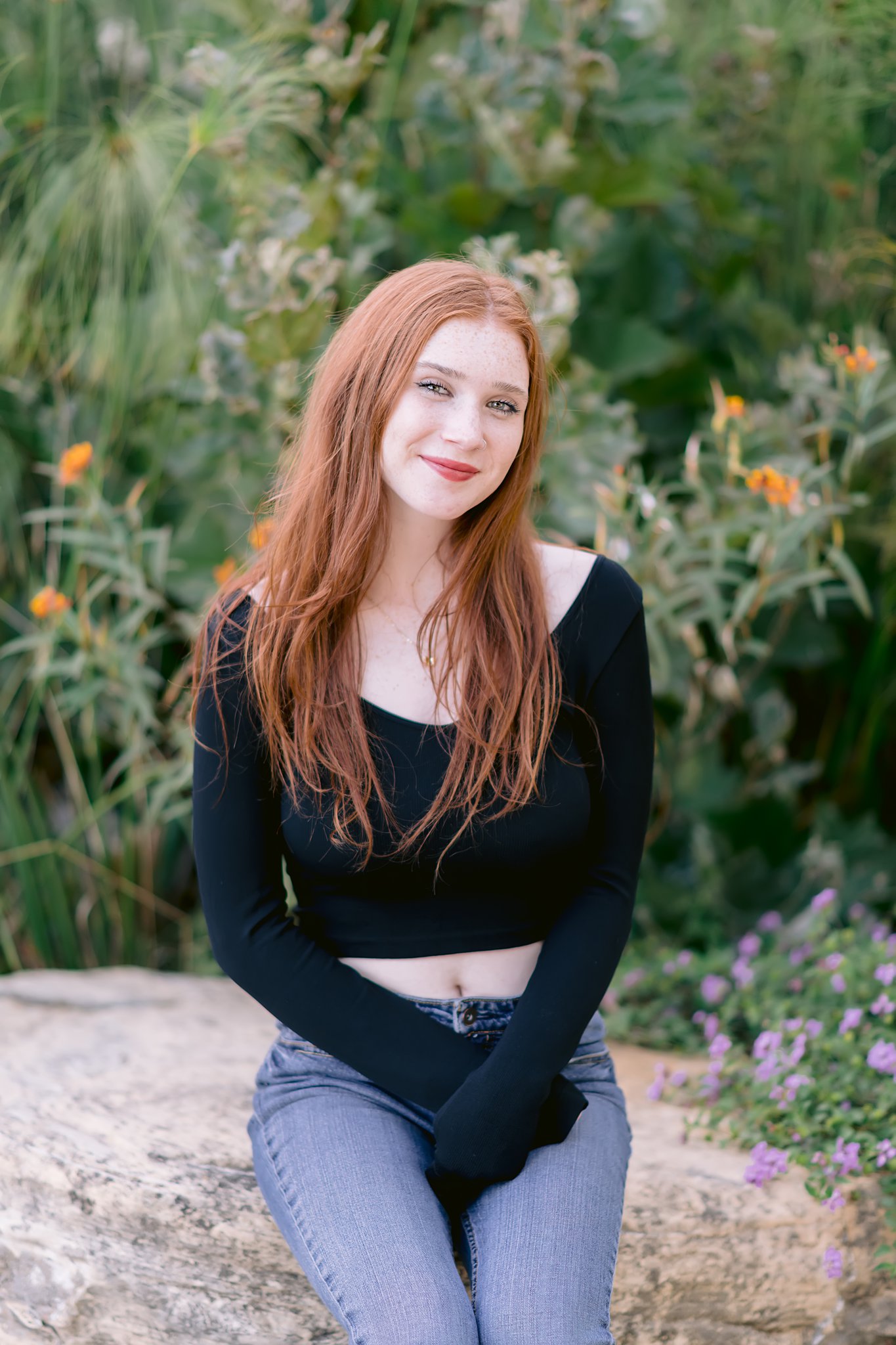 high school senior with red hair sitting on a stone wall wearing a black shirt and blue jeans after a San Luis Obispo tutoring session