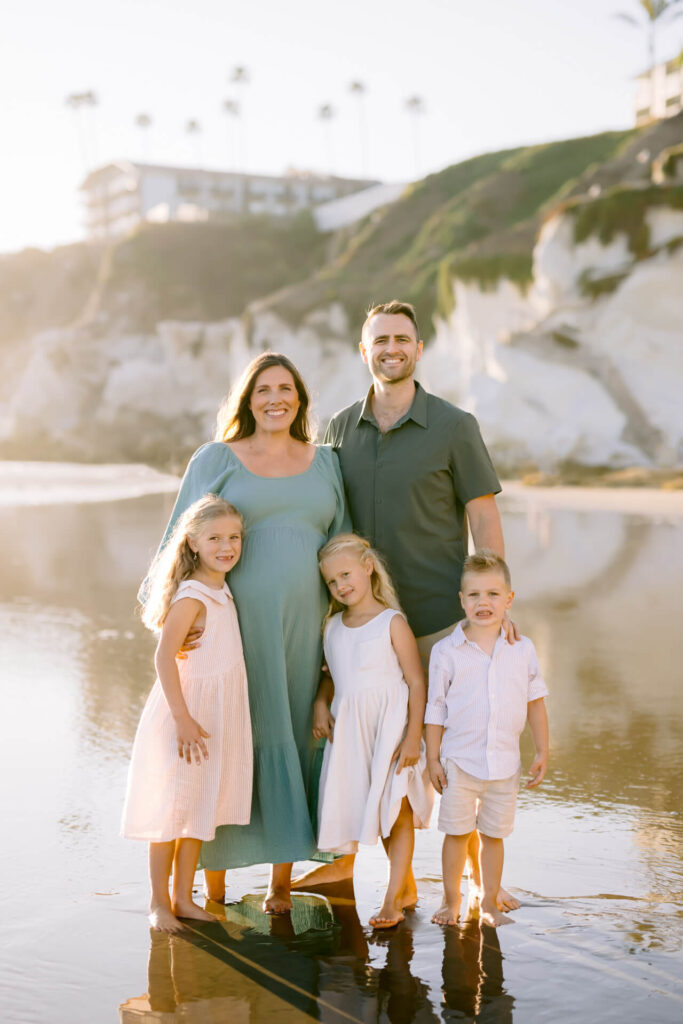 Family of five at Pismo Beach posing for a family photo at sunset